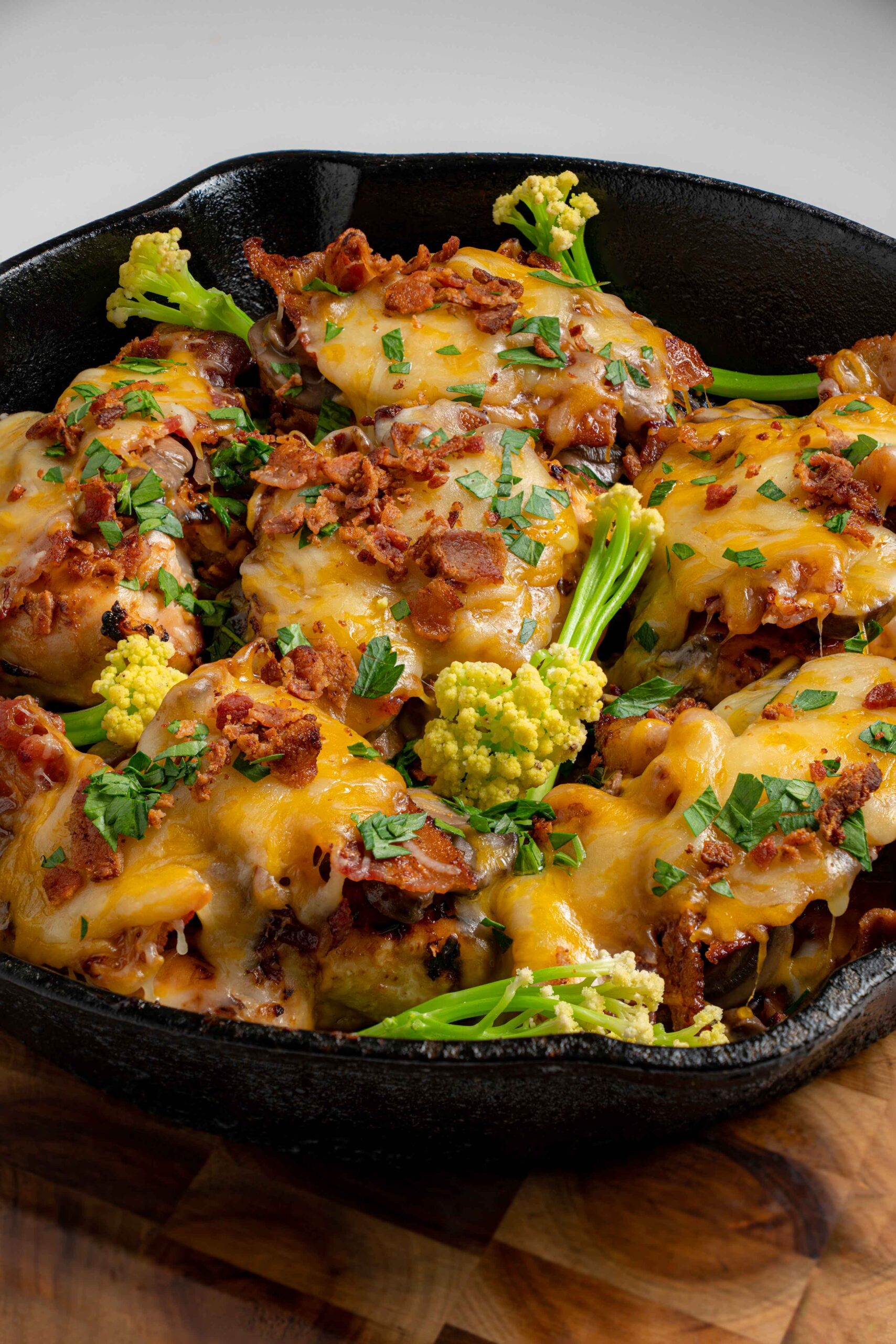 Smothered grilled chicken with melted cheese, bacon, and herbs in a cast iron skillet — recipe by Food Color Spice